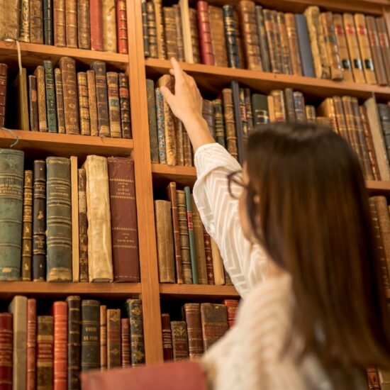 excellent-female-student-choosing-vintage-book-library_23-2148204331